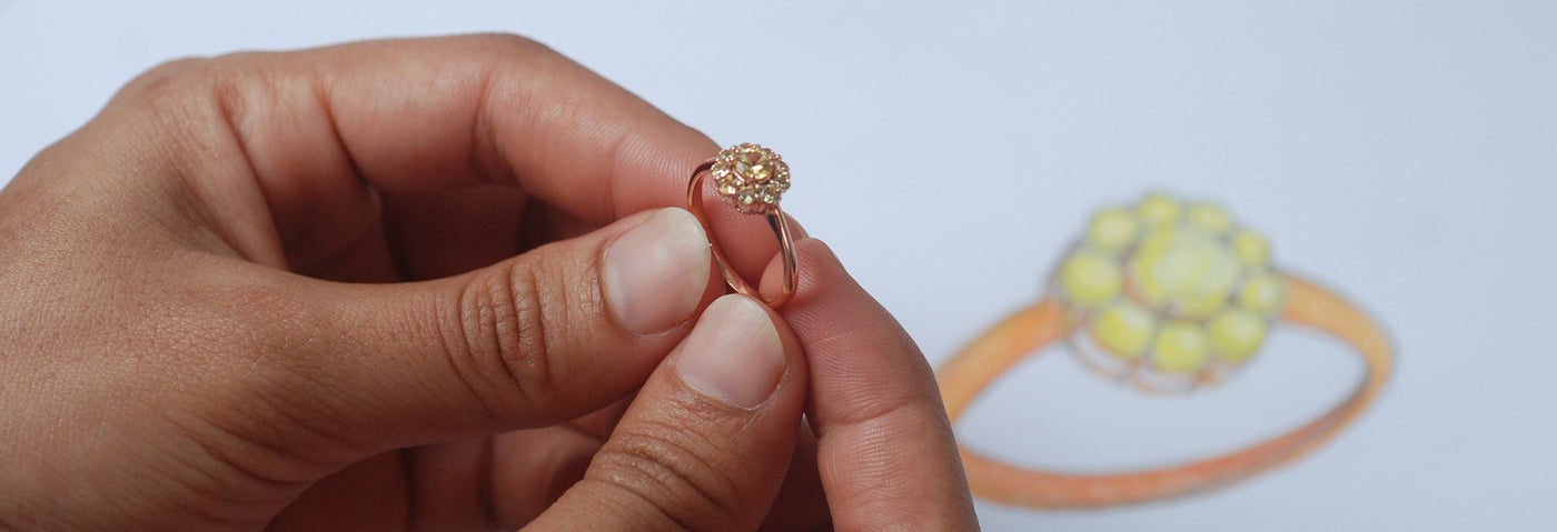 Hand holding a gold ring with a blurred background